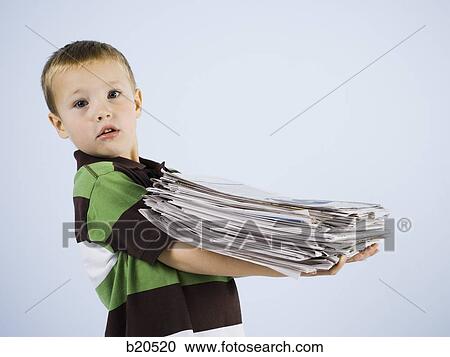 Stock Image - child holding a stack of newspapers. Fotosearch