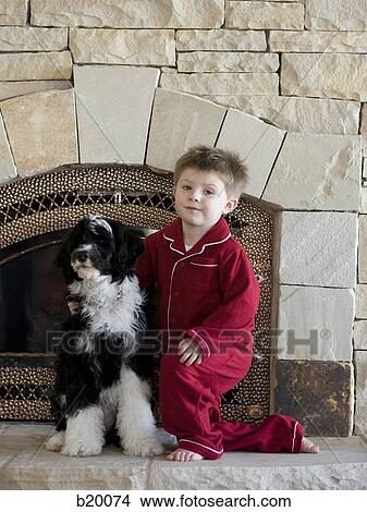 Picture - child in front of a fireplace. Fotosearch