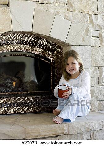 Stock Image - child in front of a fireplace. Fotosearch