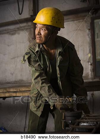Stock Image - Construction worker on a job site.. Fotosearch