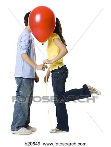 couple kissing behind a red balloon View Large Photo Image Stock Photo - couple kissing behind a red balloon. Fotosearch