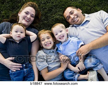 Family lying on the grass. View Large Photo Image Stock Photo - Family lying on the grass.. Fotosearch