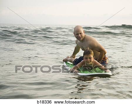 Father and son in the water with surfboard. View Large Photo Image Stock Photograph - Father and son in the water with surfboard.. Fotosearch