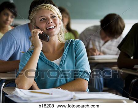 Femail Student in a classroom on a cell phone. View Large Photo Image Stock Photo - Femail Student in a classroom on a cell phone.. Fotosearch