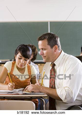 Stock Image - Female Student and teacher in a classroom.. Fotosearch