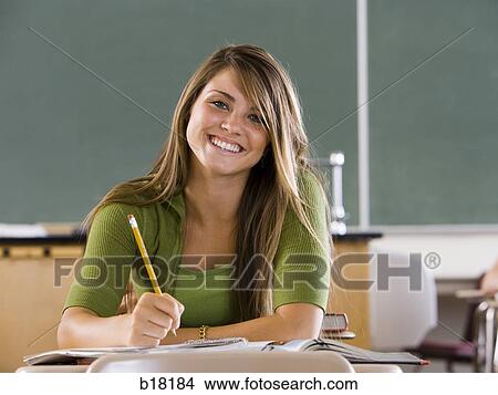 Female student in a classroom on a cell phone. View Large Photo Image Picture - Female student in a classroom on a cell phone.. Fotosearch