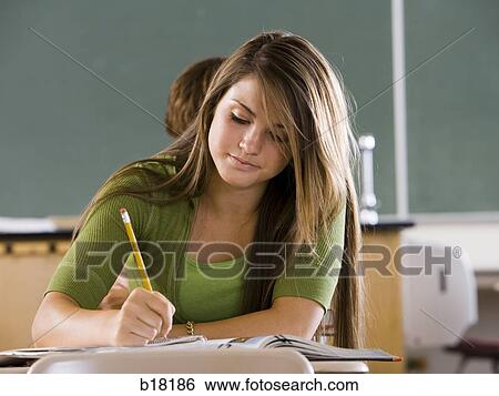Stock Photograph - Female student in a classroom on a cell phone.. Fotosearch