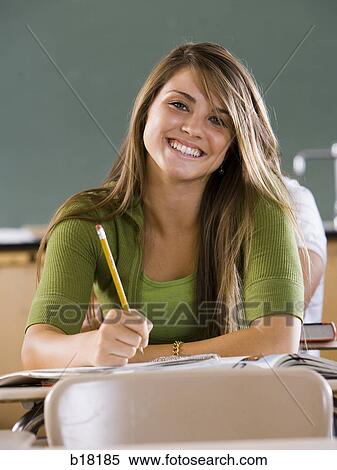 Stock Photography - Female student in a classroom on a cell phone.. Fotosearch