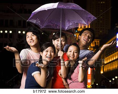 Five young people under an umbrella. View Large Photo Image Stock Image - Five young people under an umbrella.. Fotosearch