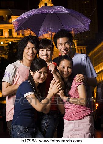 Five young people under an umbrella. View Large Photo Image Stock Photo - Five young people under an umbrella.. Fotosearch