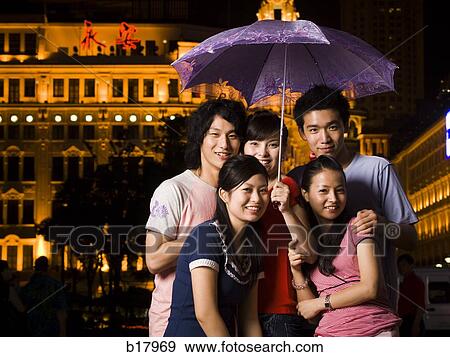 Five young people under an umbrella. View Large Photo Image Stock Photo - Five young people under an umbrella.. Fotosearch