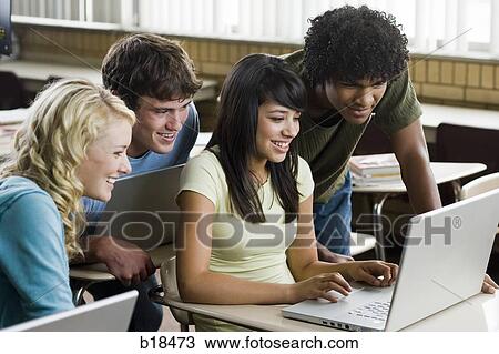 Four students crowded around a notebook computer. View Large Photo Image Stock Image - Four students crowded around a notebook computer.. Fotosearch