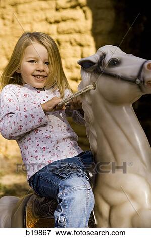 girl on a toy horse View Large Photo Image Stock Photo - girl on a toy horse. Fotosearch