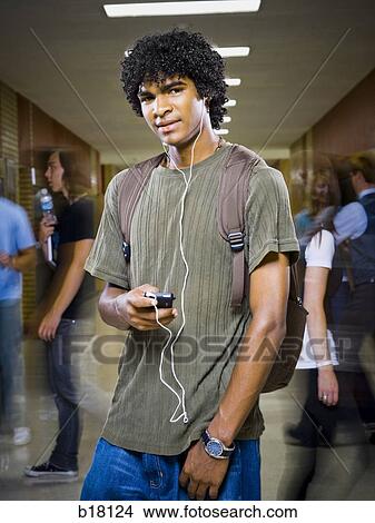 Picture - High School boy at school listening to MP3 player.. Fotosearch