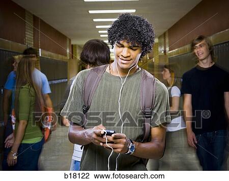 High School boy at school listening to MP3 player. View Large Photo Image Stock Image - High School boy at school listening to MP3 player.. Fotosearch