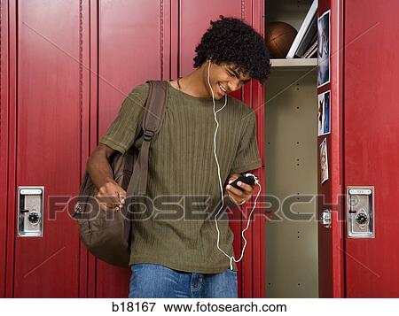 High School boy at school listening to MP3 player. View Large Photo Image Stock Photo - High School boy at school listening to MP3 player.. Fotosearch
