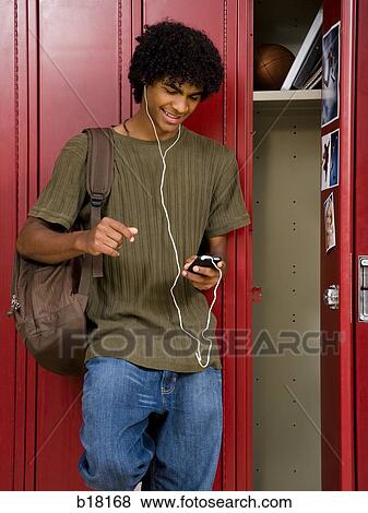 High School boy at school listening to MP3 player. View Large Photo Image Stock Photo - High School boy at school listening to MP3 player.. Fotosearch