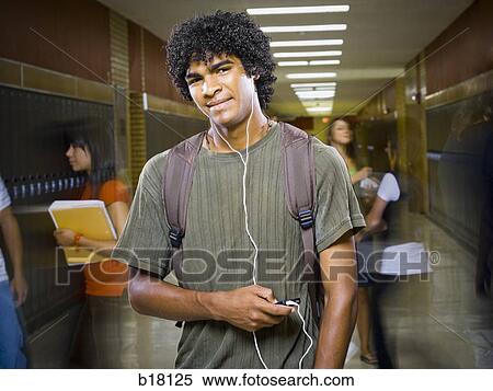 Stock Photography - High School boy at school listening to MP3 player.. Fotosearch