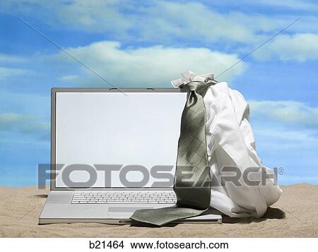 Picture - laptop in the sand. Fotosearch