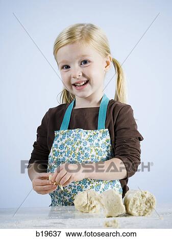 Stock Photo - little girl kneading dough. Fotosearch