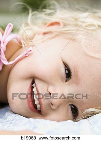 little girl lying on a blanket. View Large Photo Image Stock Photo - little girl lying on a blanket.. Fotosearch