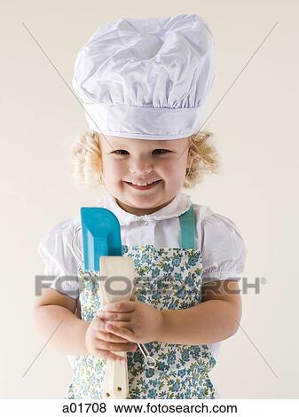 Stock Photo - Little girl wearing a chef's hat and holding spoons.. Fotosearch