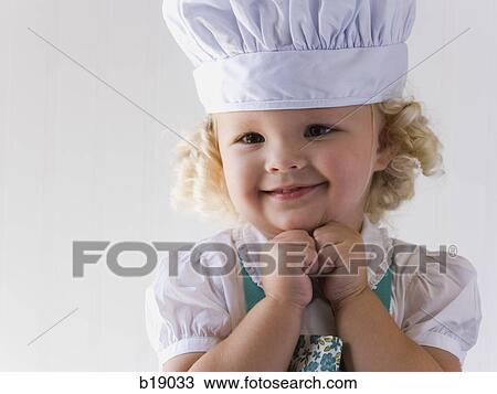 Stock Image - little girl with a chef's hat on.. Fotosearch