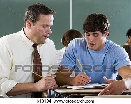 Male student and teacher in a classroom. View Large Photo Image Picture - Male student and teacher in a classroom.. Fotosearch