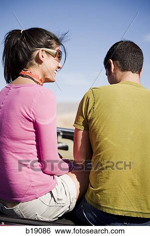 man and a woman sitting on the back of a convertible. View Large Photo Image Stock Photograph - man and a woman sitting on the back of a convertible.. Fotosearch