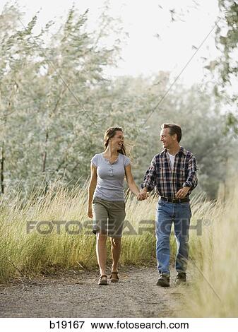man and woman holding hands and walking. View Large Photo Image Stock Photo - man and woman holding hands and walking.. Fotosearch