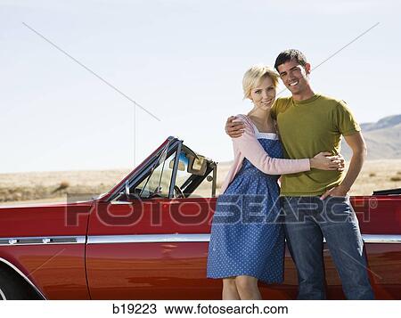 man and woman next to a red convertible View Large Photo Image Stock Image - man and woman next to a red convertible. Fotosearch