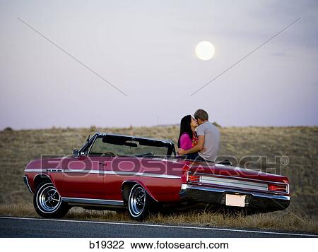 man and woman next to a red convertible View Large Photo Image Stock Image - man and woman next to a red convertible. Fotosearch