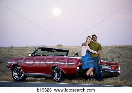 man and woman next to a red convertible View Large Photo Image Stock Image - man and woman next to a red convertible. Fotosearch