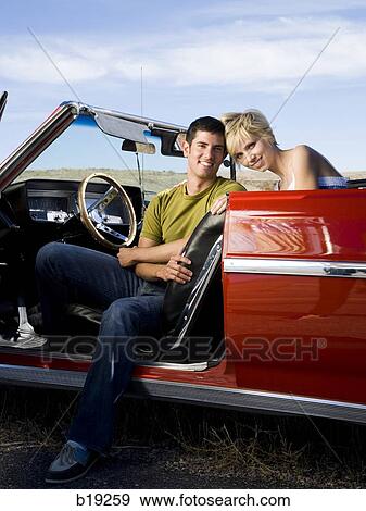man and woman next to a red convertible View Large Photo Image Stock Photo - man and woman next to a red convertible. Fotosearch