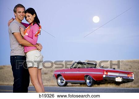 man and woman next to a red convertible View Large Photo Image Stock Photograph - man and woman next to a red convertible. Fotosearch