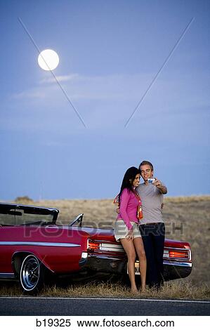 man and woman next to a red convertible View Large Photo Image Stock Photography - man and woman next to a red convertible. Fotosearch