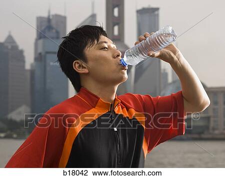 Stock Image - Man drinking bottled water.. Fotosearch
