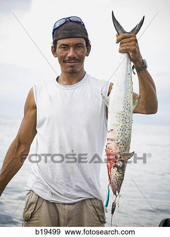 man holding a fish View Large Photo Image Stock Photo - man holding a fish. Fotosearch