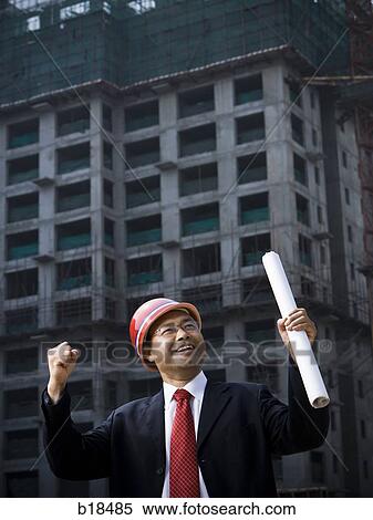 Man in suit on a construction job site with plans in hand. View Large Photo Image Stock Photography - Man in suit on a construction job site with plans in hand.. Fotosearch