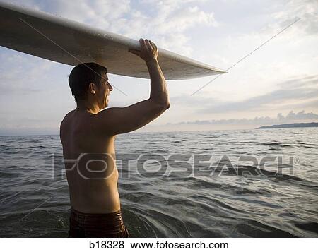 Man in the water with surfboard. View Large Photo Image Stock Photo - Man in the water with surfboard.. Fotosearch