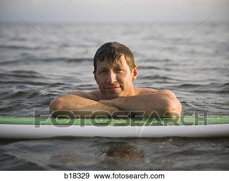 Stock Photo - Man in the water with surfboard.. Fotosearch