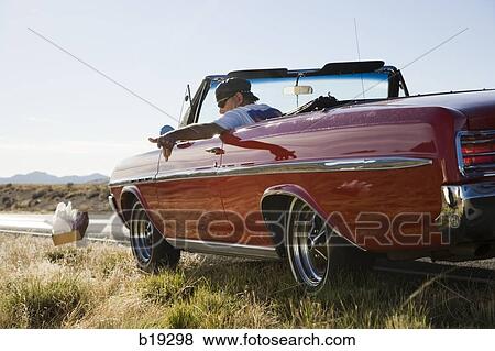 Stock Photo - man littering out of a car. Fotosearch