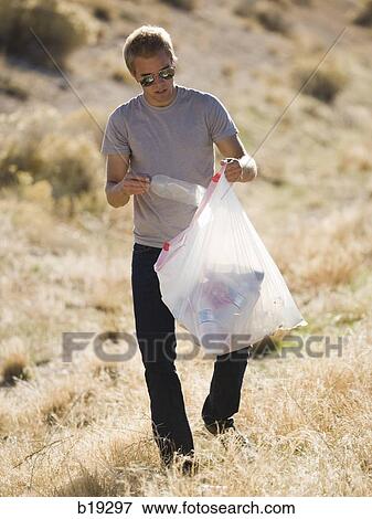 man picking up trash on the side of the road View Large Photo Image Stock Photo - man picking up trash on the side of the road. Fotosearch
