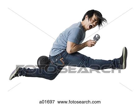 Stock Photo - Man rocking out with mic stand.. Fotosearch