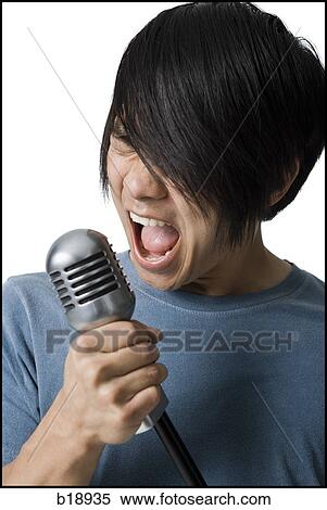 Stock Photography - Man rocking out with mic stand.. Fotosearch