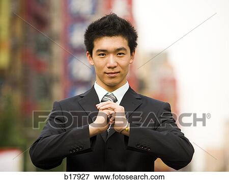 Stock Photo - Man standing on a busy city street bowing.. Fotosearch