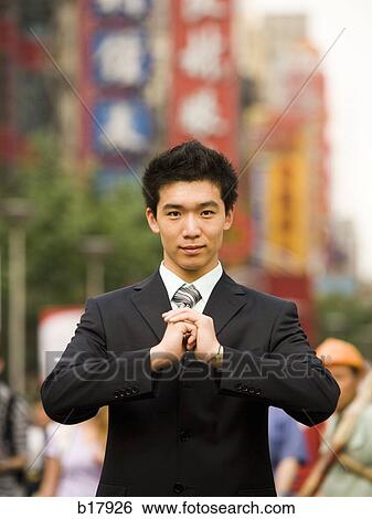 Man standing on a busy city street bowing. View Large Photo Image Stock Photograph - Man standing on a busy city street bowing.. Fotosearch