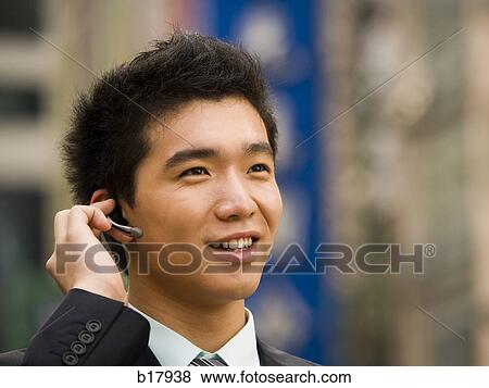 Stock Photo - Man with a cell phone earpiece.. Fotosearch