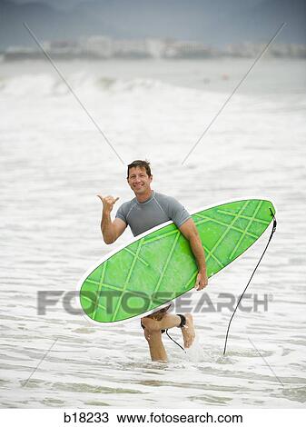 Man with surfboard at the beach. View Large Photo Image Stock Image - Man with surfboard at the beach.. Fotosearch