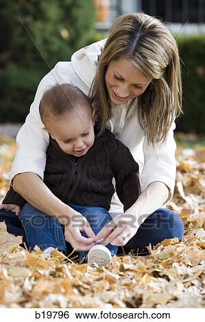 mother and baby playing in fallen leaves View Large Photo Image Stock Photograph - mother and baby playing in fallen leaves. Fotosearch